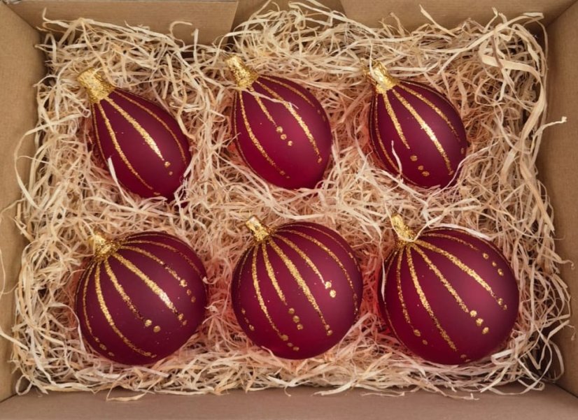 Kézzel díszített piros karácsonyi gömbök arany csíkokkal Kézzel díszített piros karácsonyi gömbök arany csíkokkal