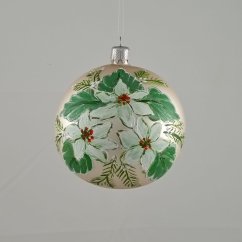 Üveges karácsonyi gömb tejszínszínű háttérrel és fehér karácsonyi virágokkal