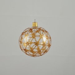 Průhledná skleněná koule se zlatým třpytivým vzorem pavučiny.